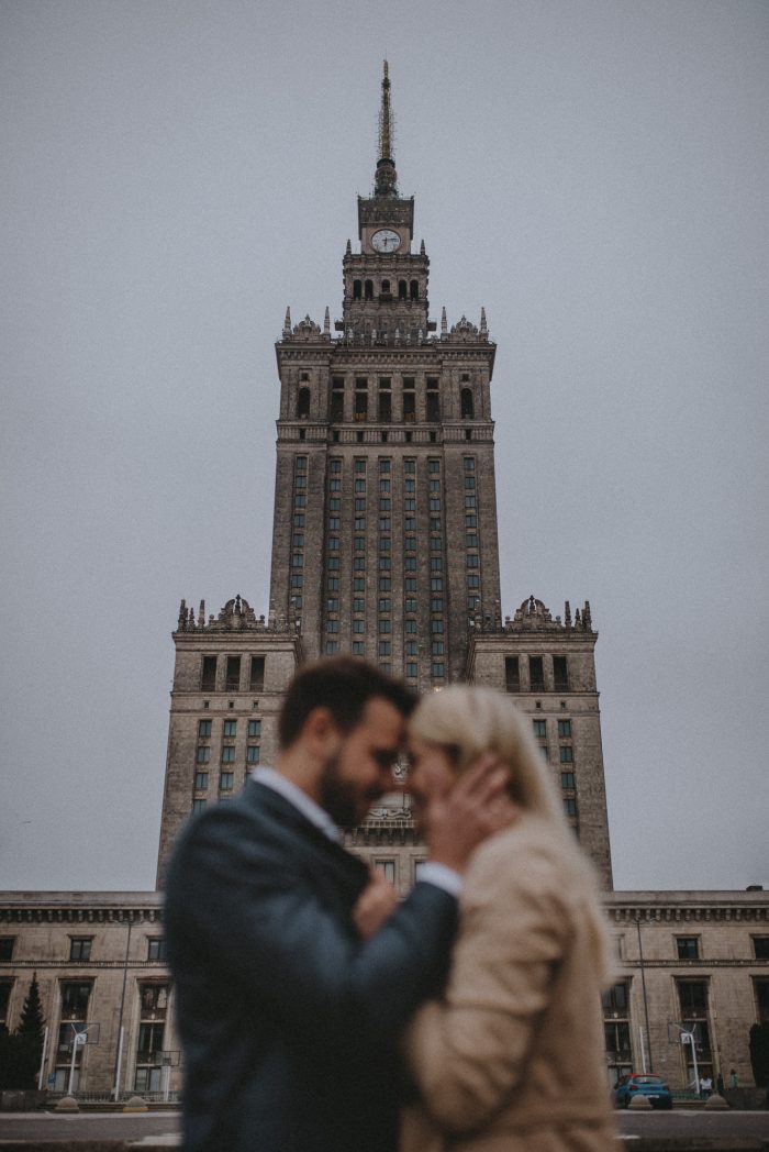 couple blurred in front of dramatic building