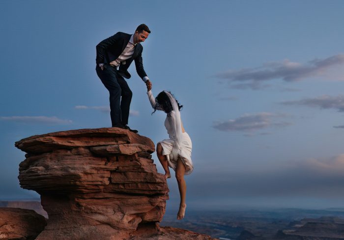 bride and groom climbing mountain