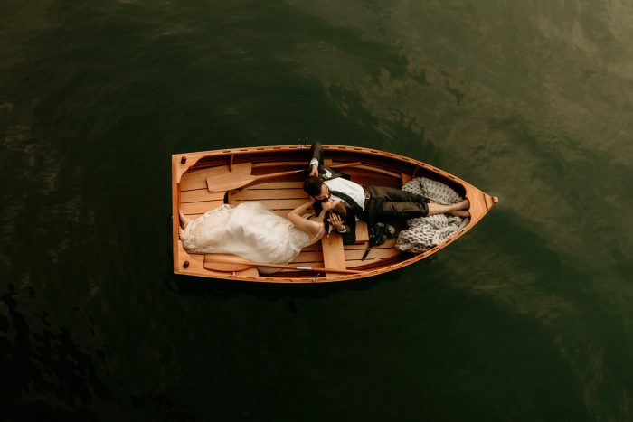 bride and groom laying in row boat