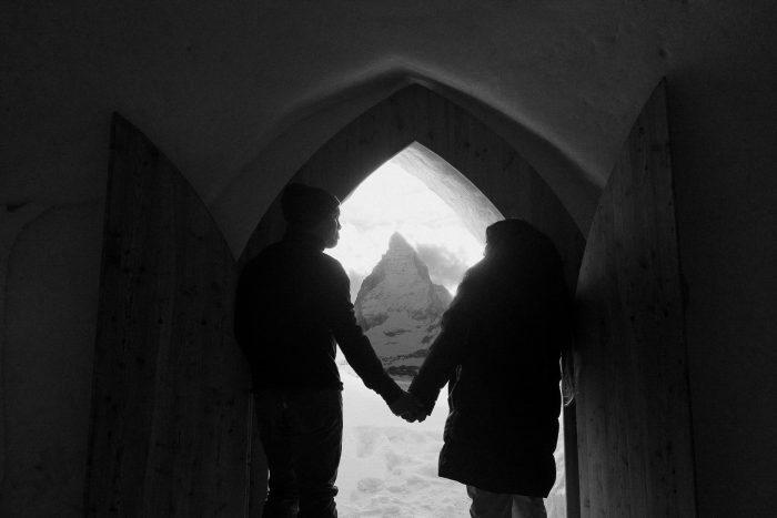 black and white photo of couple in front of door