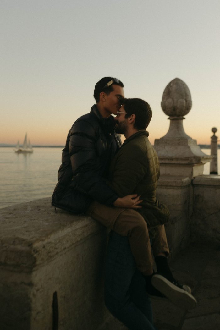 same sex couple kissing at sunset