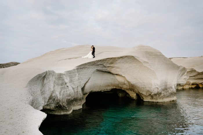 wedding photo on giant rock over water