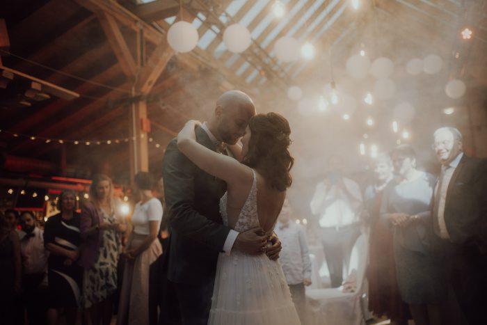 couple dancing in smoke-filled barn on wedding day