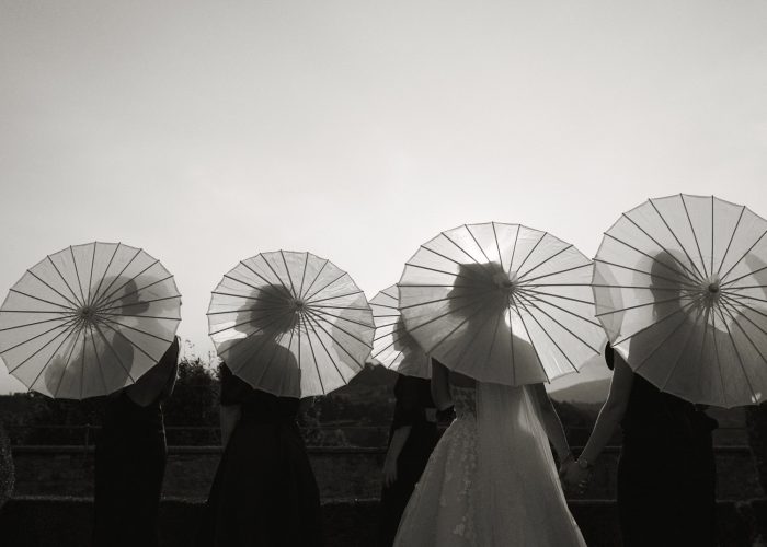 bride and bridesmaids holding parasols 