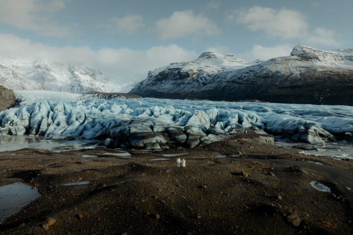 couple in iceland by glaciers