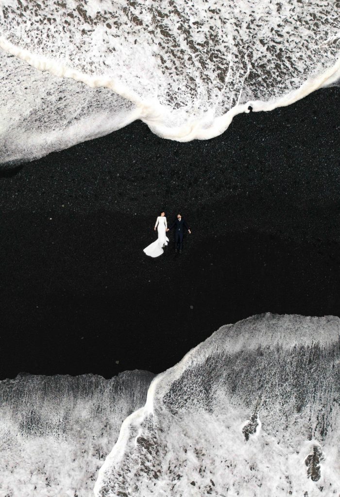 wedding couple lying on black beach