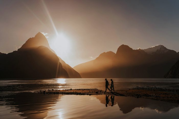 couple walking on beach at sunset